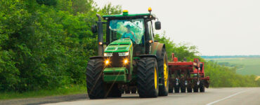 Trator com plantadeira acoplada transita por rodovia, simbolizando as novas normas que regulamentam trânsito de máquinas agrícolas e que tiveram contribuição do Sistema FAEP para serem efetivadas